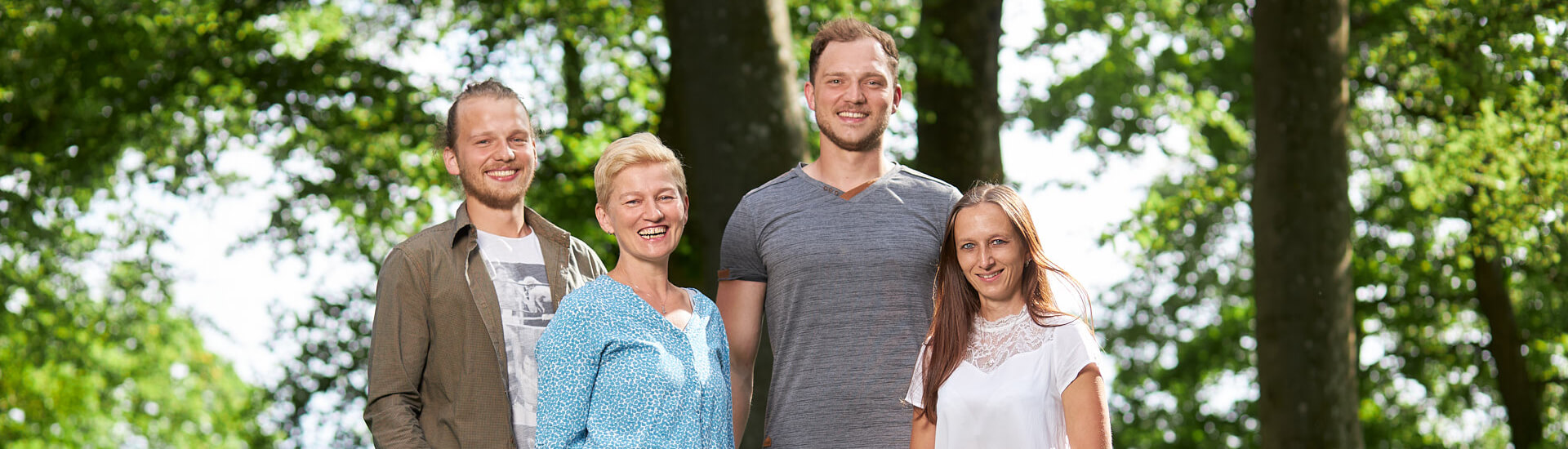 Alle Teammitglieder stehen freundlich auf einer Wiese